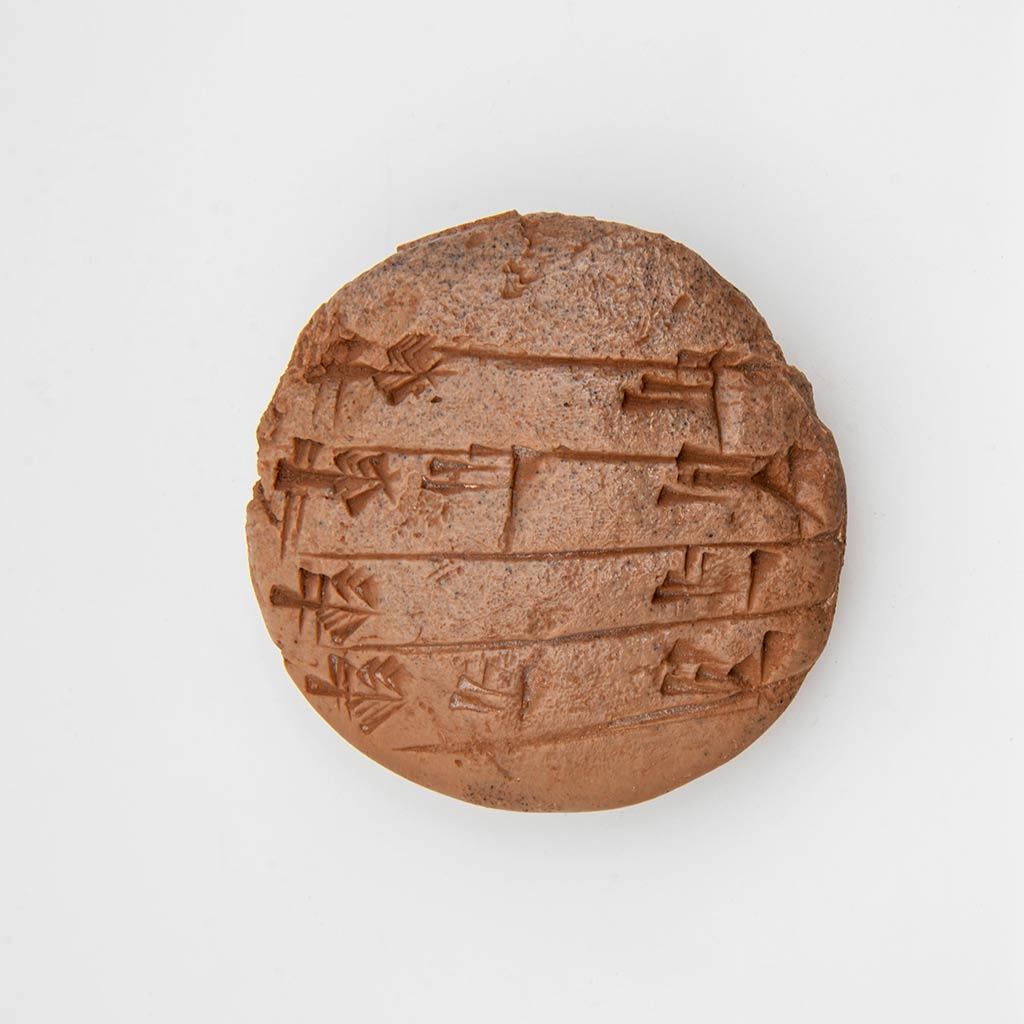 a brown circular clay tablet with cuneiform on a gray background