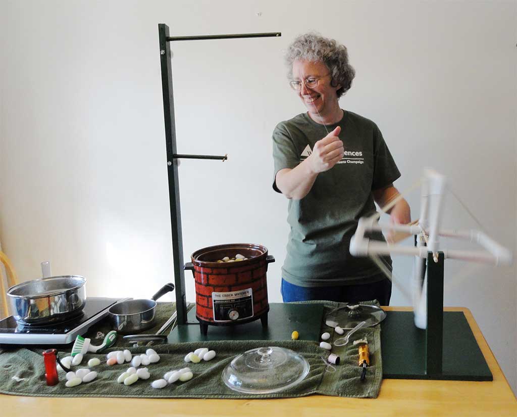 woman working with silk thread at a table of various supplies