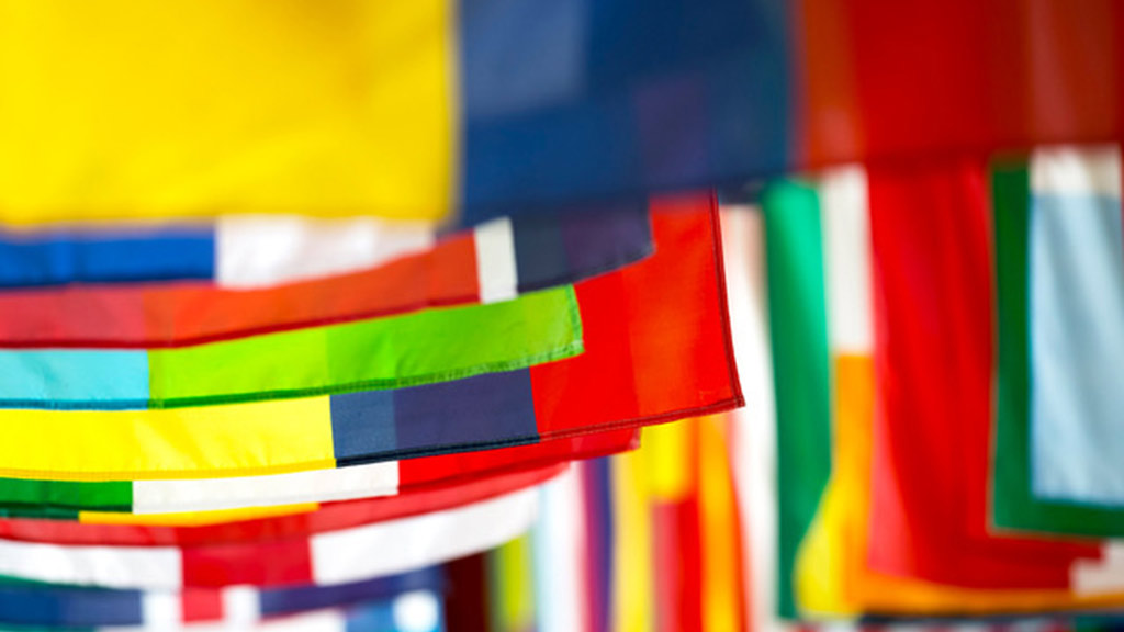 Lines of colorful flags with camera focus on 4th and 5th flag from camera.