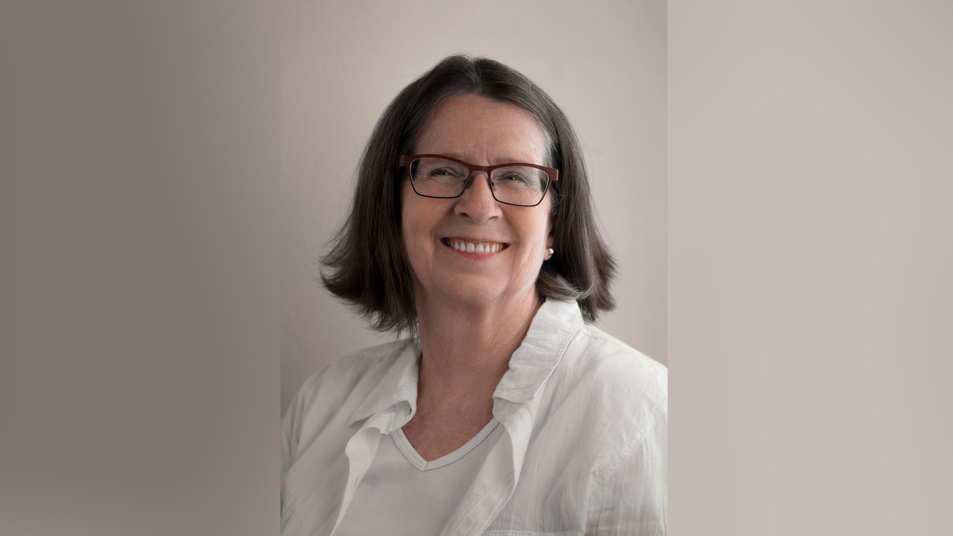 headshot portrait of middle-aged woman with glasses