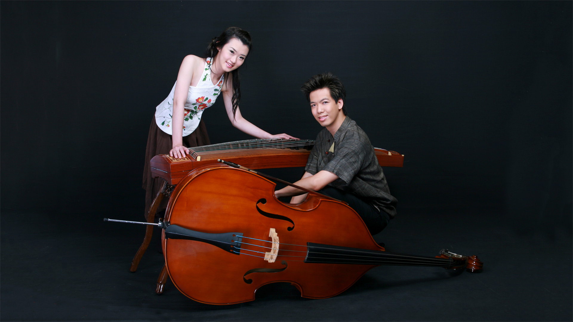Yu-Chen Wang and Han-Jui Chen posing next to their double bass and gu-zheng
