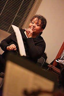 woman holding up her finger to her mouth and looking at the camera