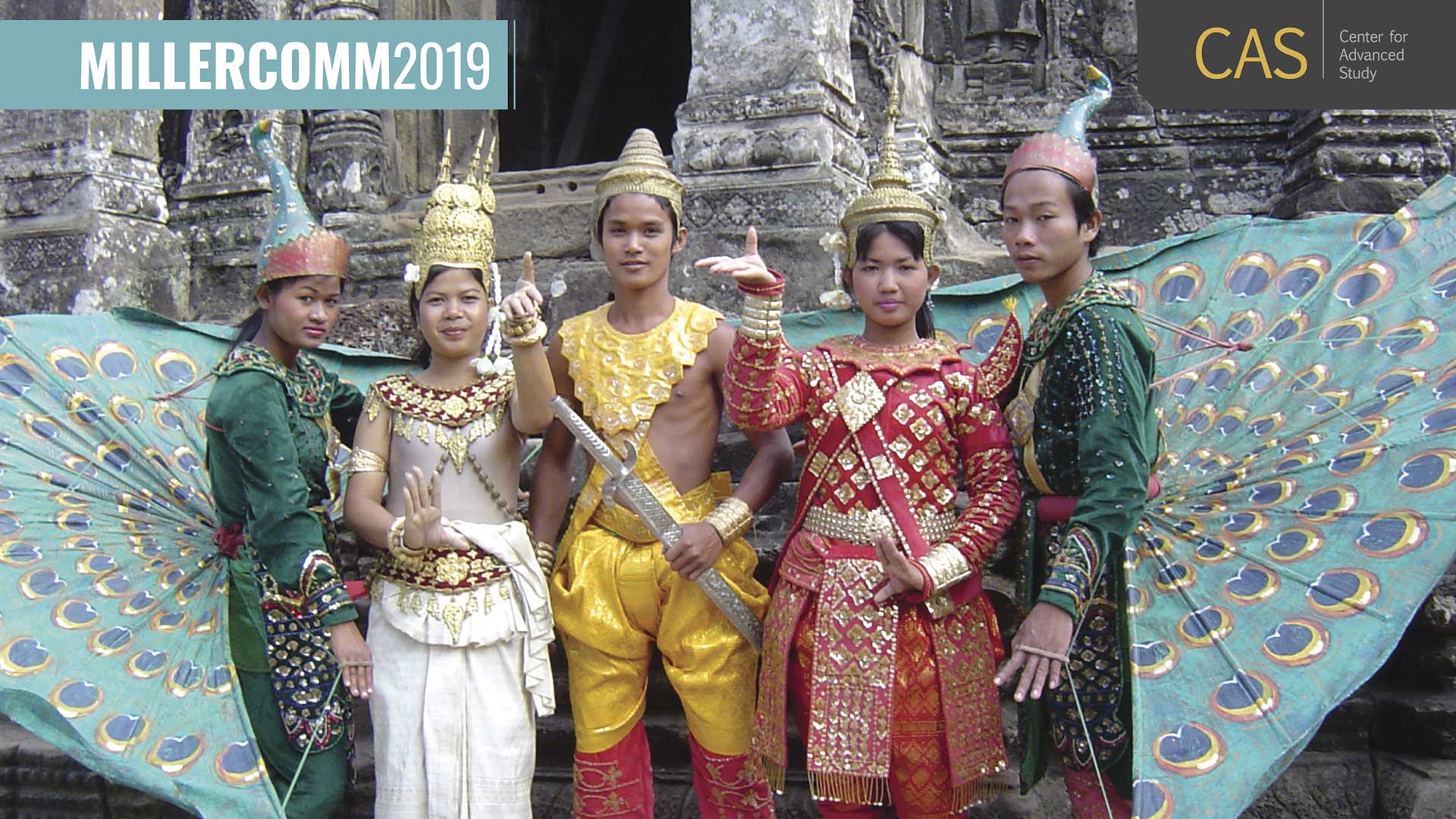 5 people in traditional southeast asia costumes pose in front of a weathered temple-style building