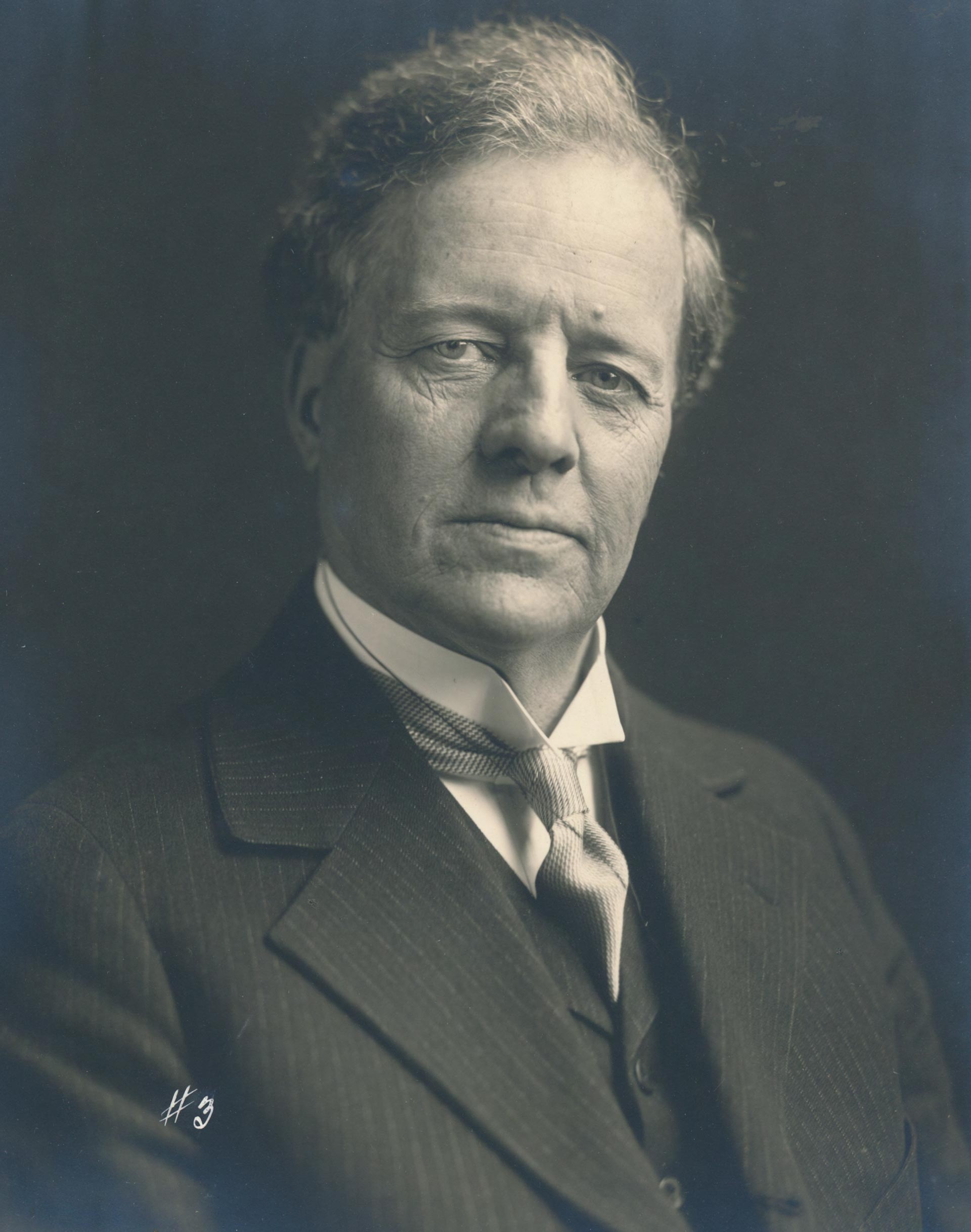 Portrait shot of Edmond James in a suit looking at the camera