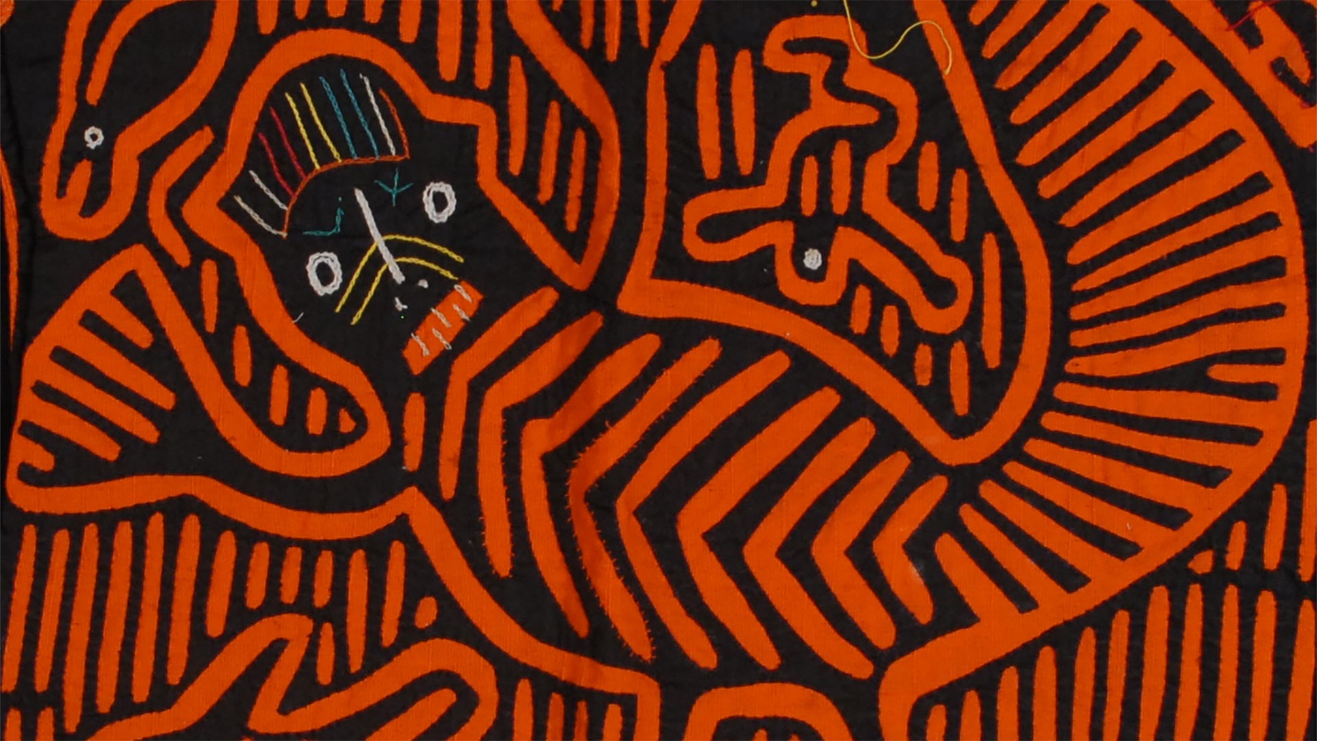 geometric pattern in orange and black of a small animal on fabric