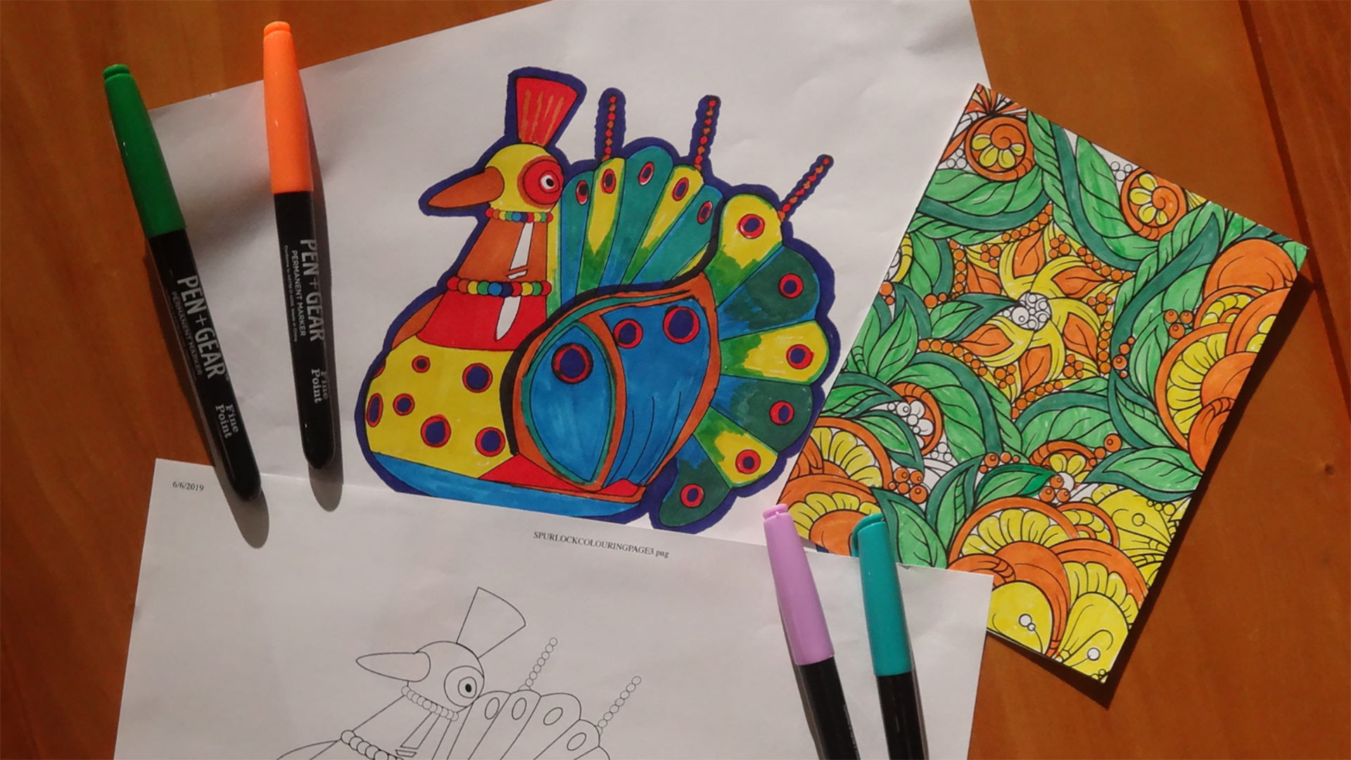 partially colored coloring sheets with a peacock and geometric design alongside 4 colored markers