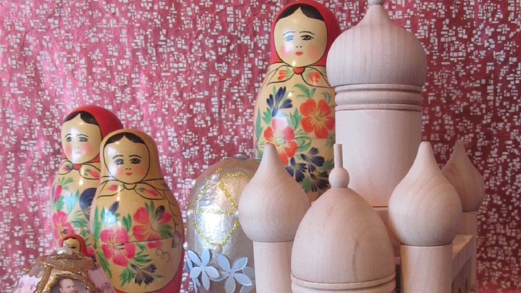 Russian Dolls arranged around wooden temple figures on table