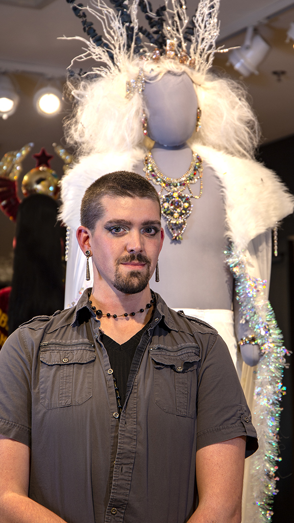 artist standing next to dressed up mannequin