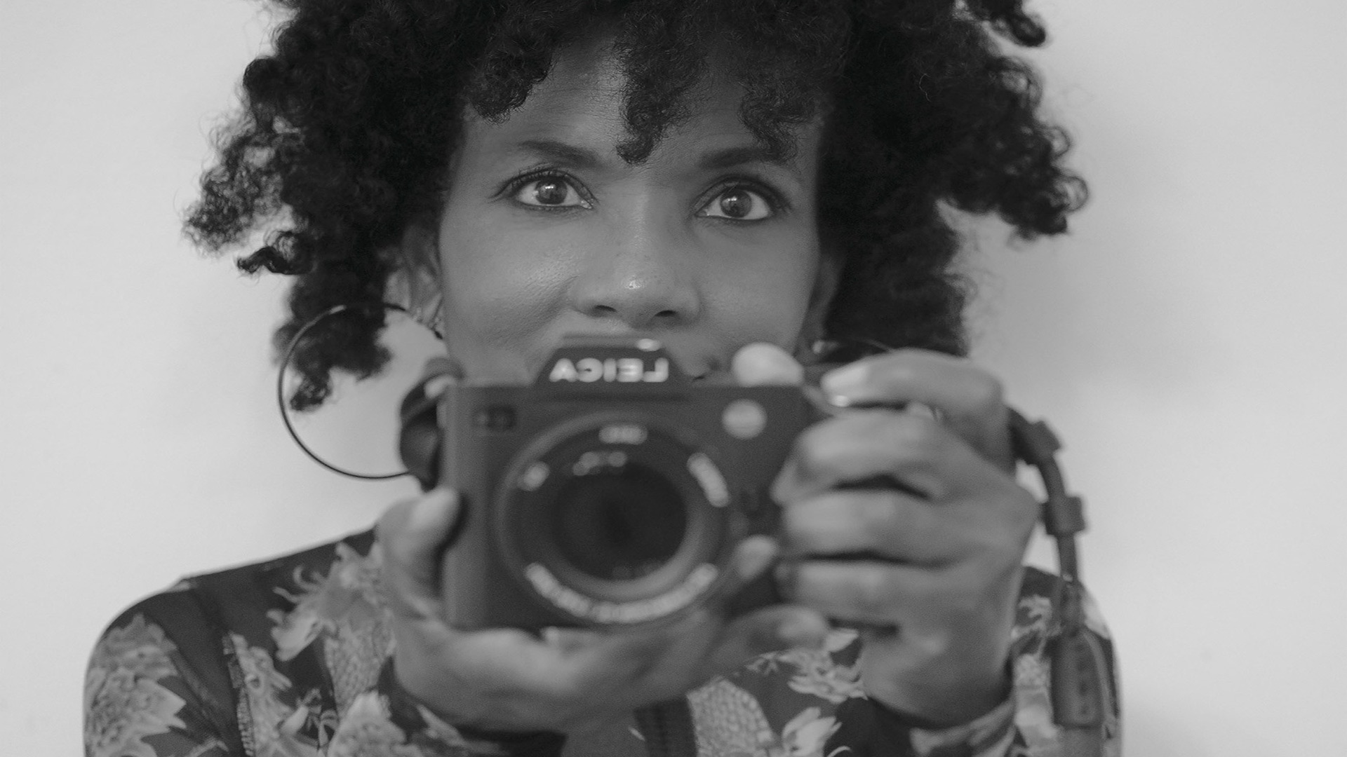 Shelia taking a picture of herself in the mirror with a camera