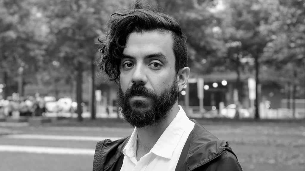 A photo of Kaveh Akbar in black and white