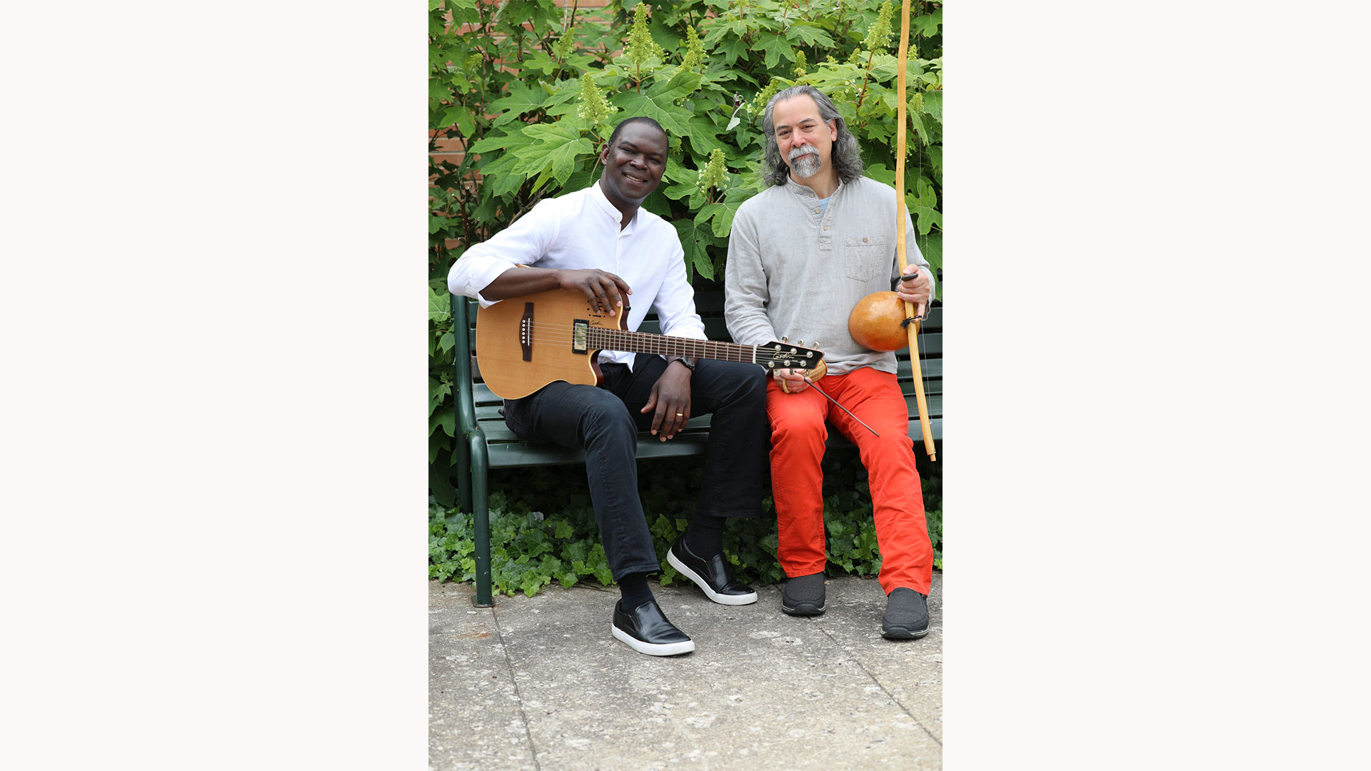 image of Bourema Ouedraogo with a guitar and Jason Finkelman with another instrument sitting next to each other