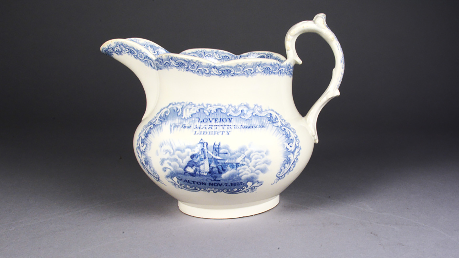White pitcher with blue design that reads 
