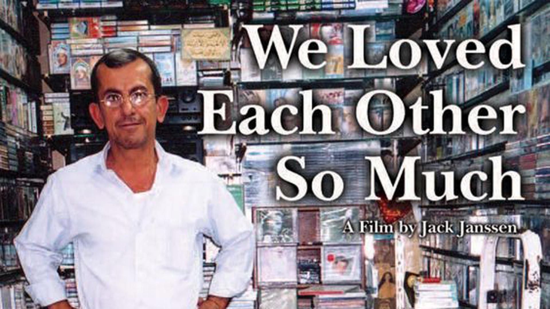 picture of a man in glasses with DVDs on the shelves behind him