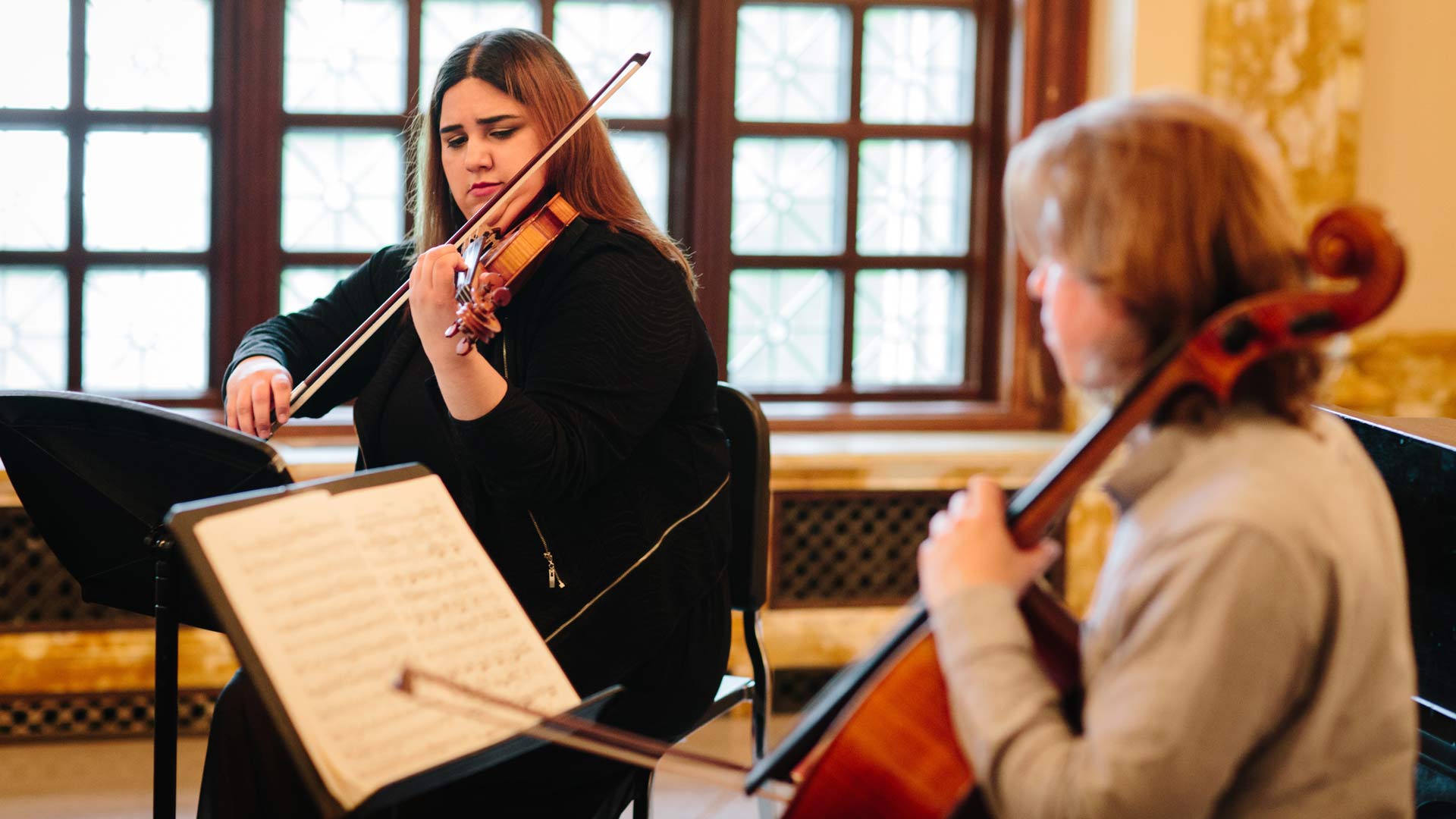 one woman playing a violin and another woman playing a cello