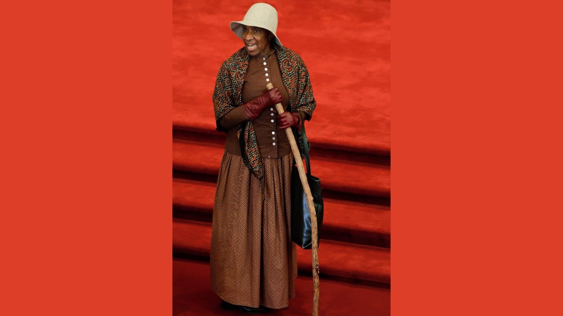 kathryn harris dressed as harriet tubman speaking and holding a walking stick