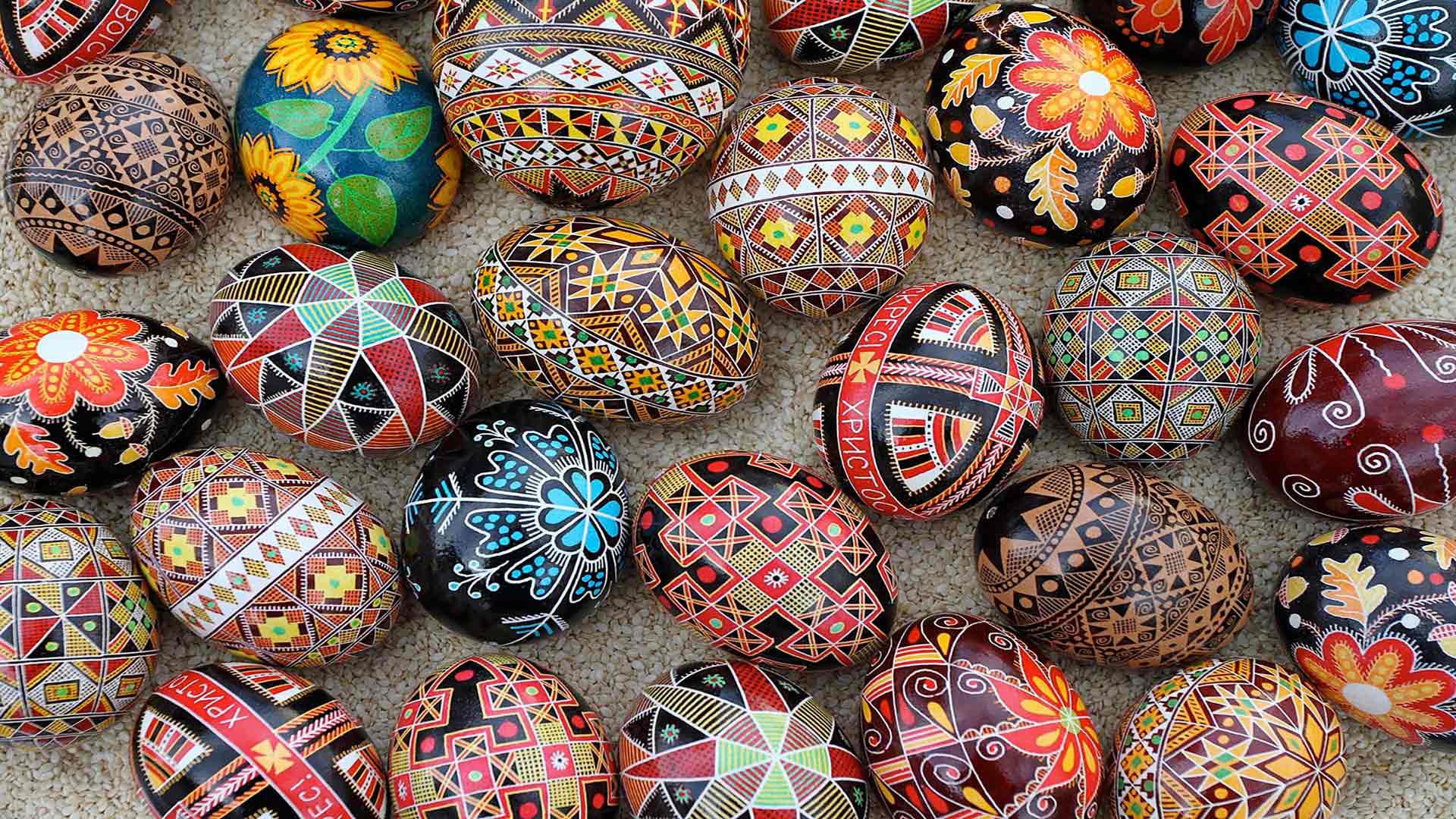 Photo of multiple decorated eggs lying on a gray surface