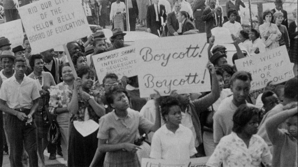 Black protesters gather with signs reading "Boycott!" and "Chicago