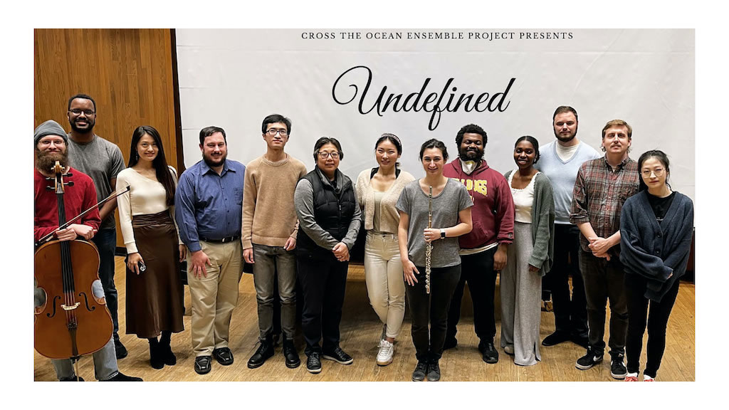 Members of Ocean Ensemble members standing in front of Undefined banner