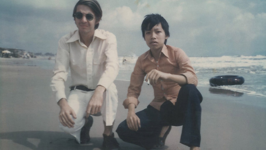 Two males crouching on the beach