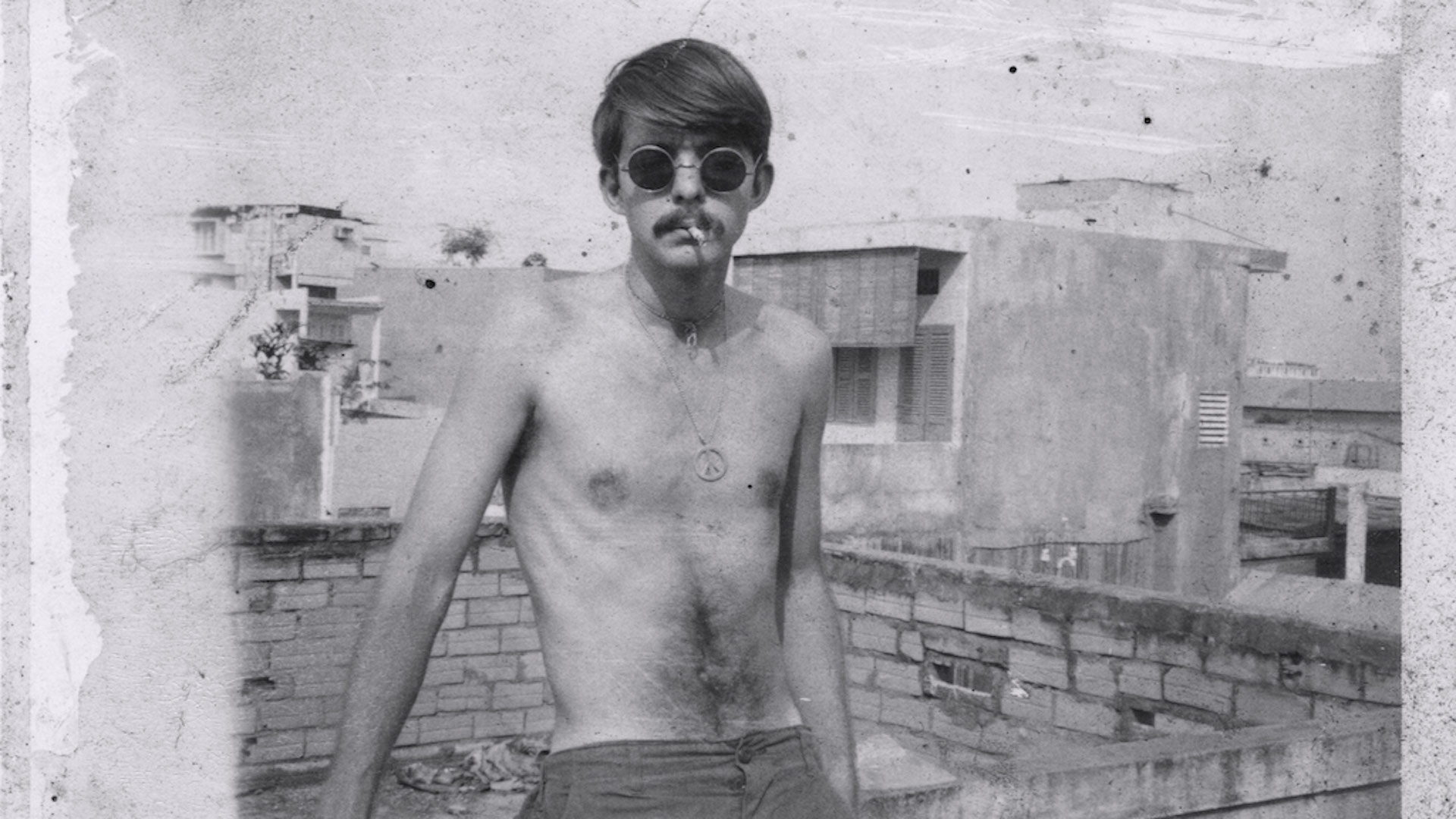 Black and white photo of Jimmy in Saigon with sun glasses on a terrace
