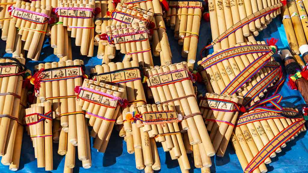 multiple pan pipes of varying sizes resting on a blue table