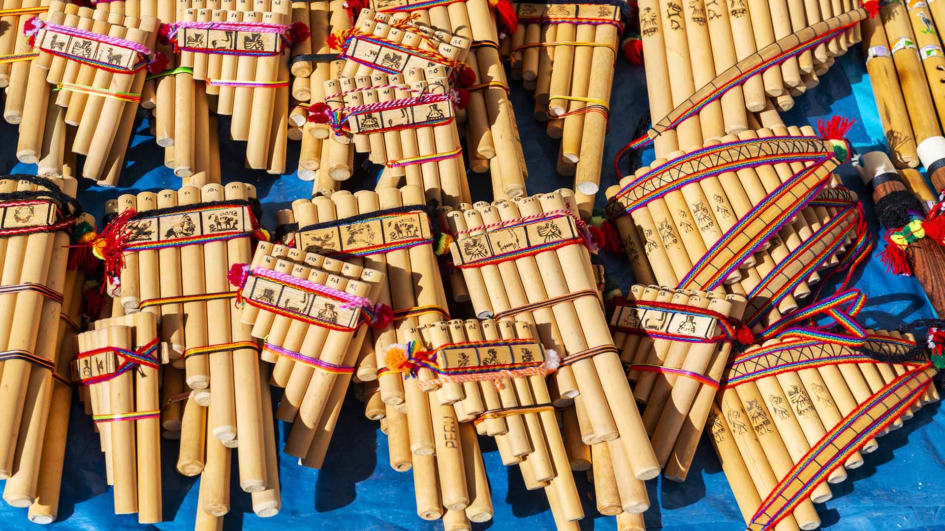 multiple pan pipes of varying sizes resting on a blue table