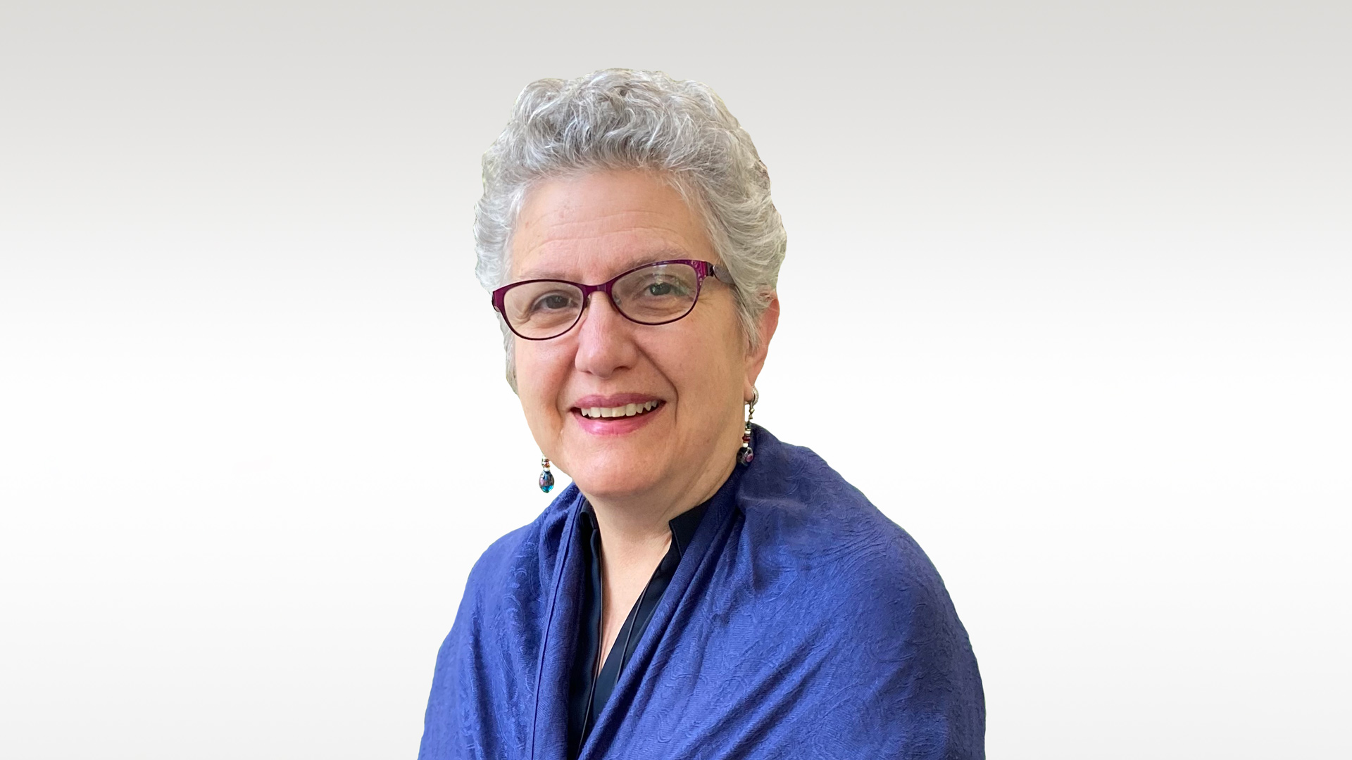 portrait of a woman with glasses and gray hair on a white background