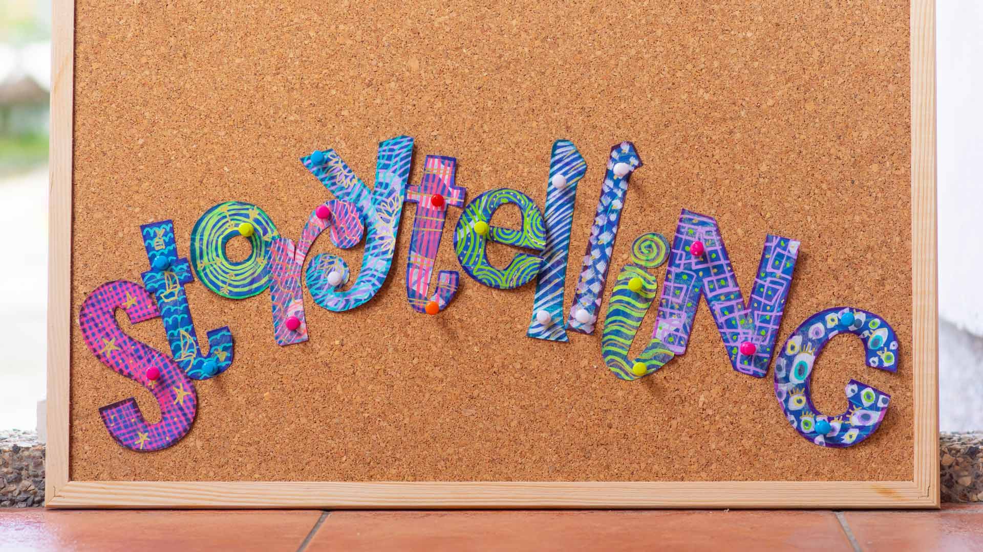 Cut-out letters that spell 'Storytelling' pinned to a corkboard