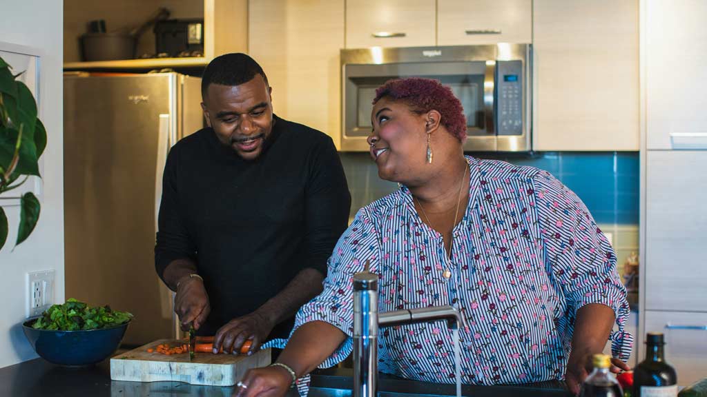 Black man and woman couple cooking in the kitchen