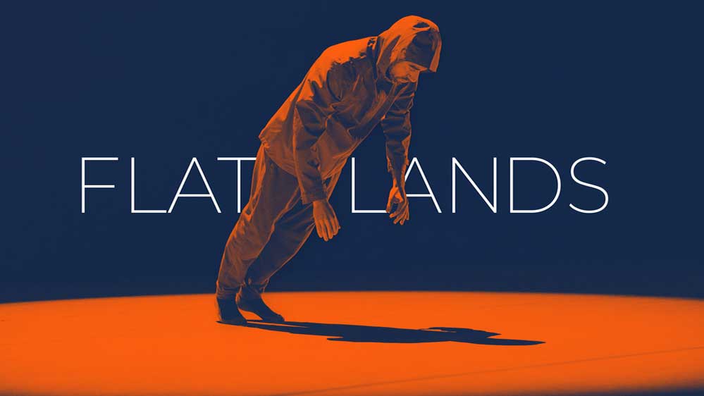 flatlands logo with stylized male dancer leaning forward into the spotlight