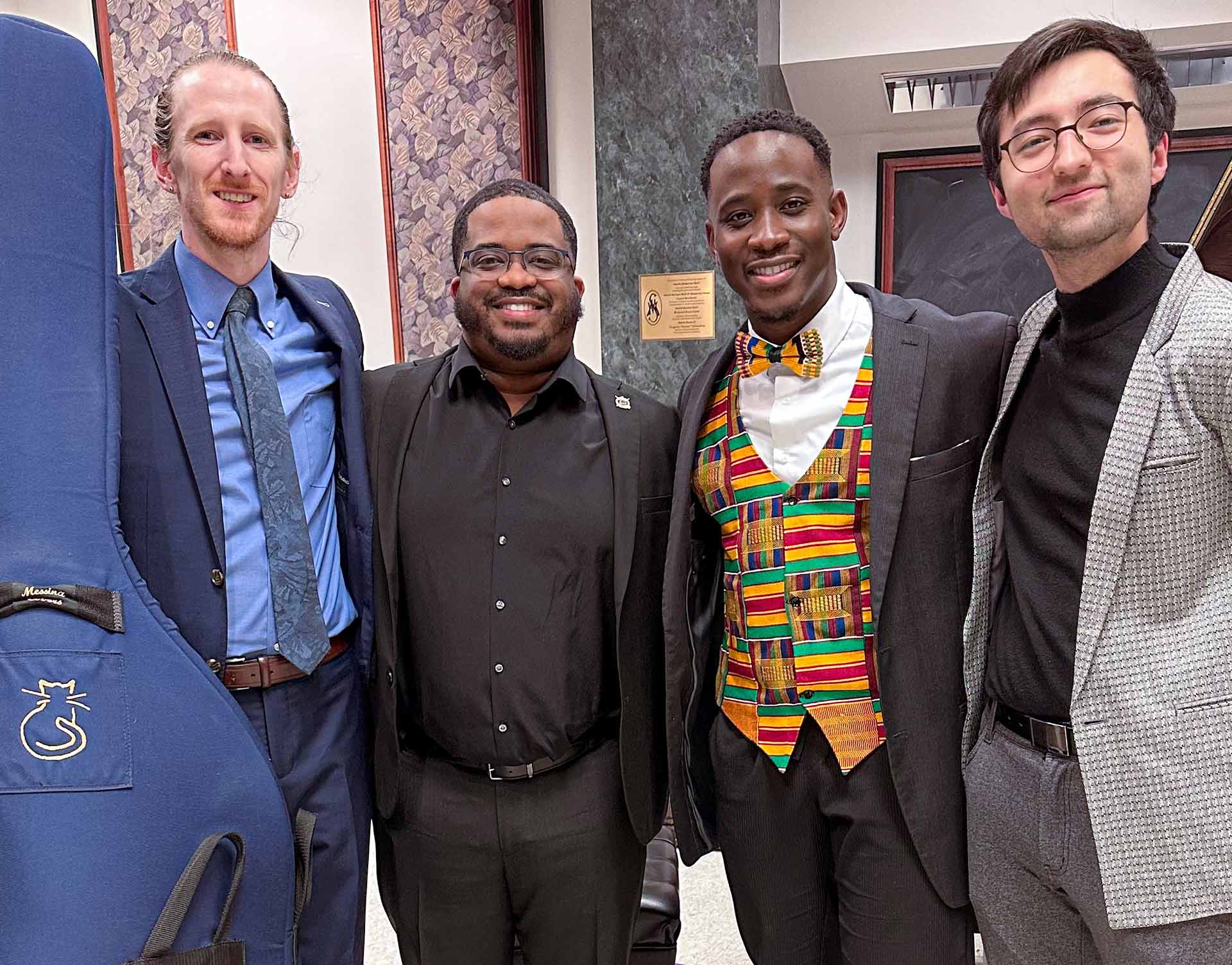 a group of men smiling while standing side by side one another.