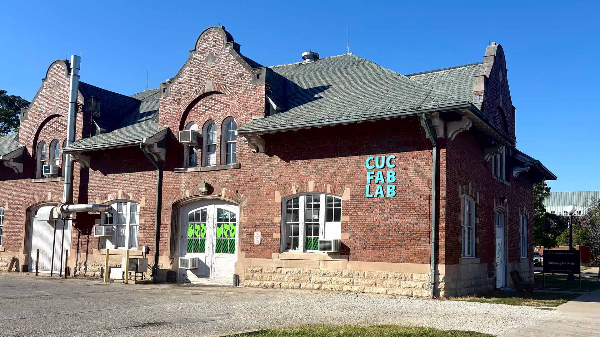 Early 20th century red brick laboratory build with friend CUC FAB LAB lettering on the outside