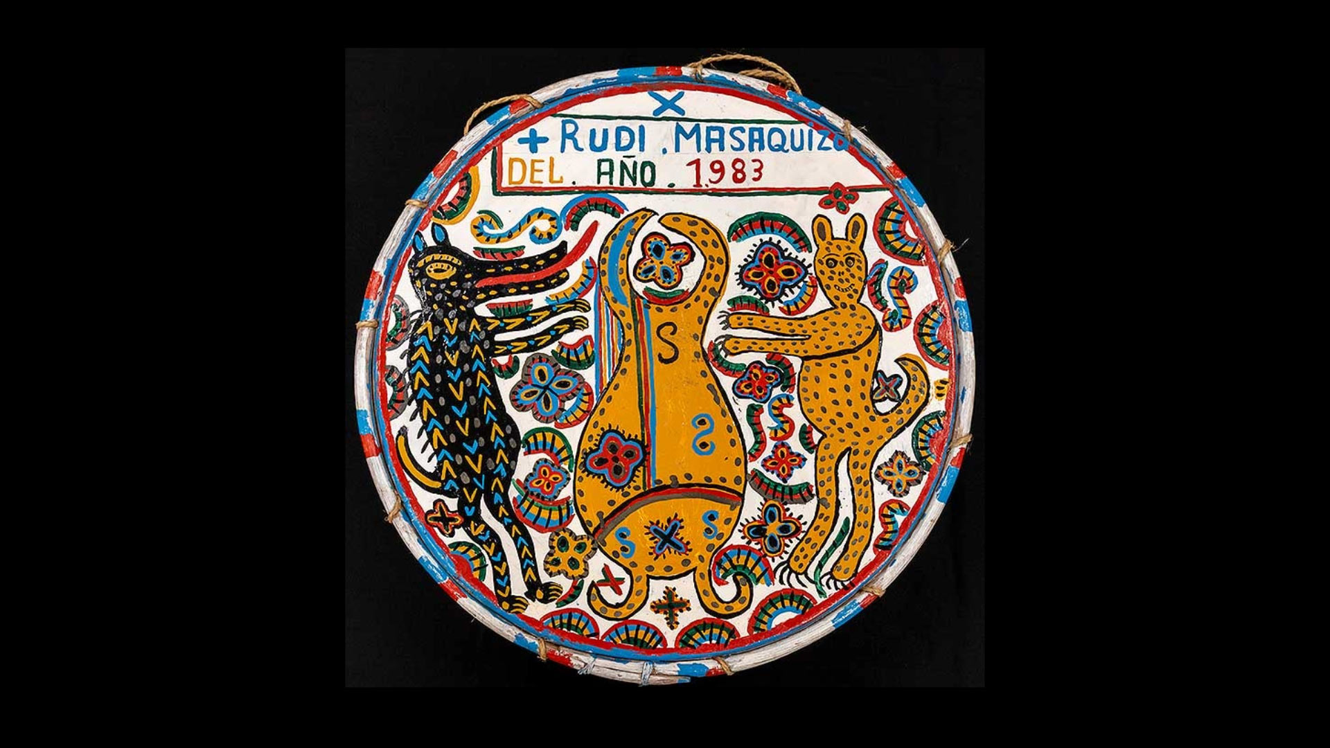 A circle medallion with a tribal pattern that says "Rudi, Masaquiza, Del, Ano, 1983" at the top.