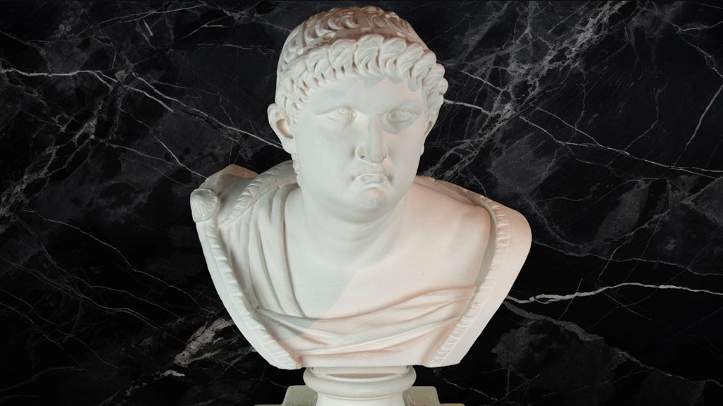 White bust of a man on top of a black marble background