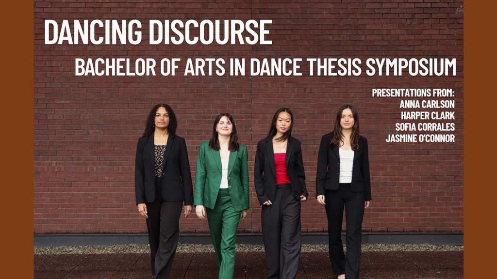 Four students in business attire  in front of a brick wall walking towards the camera