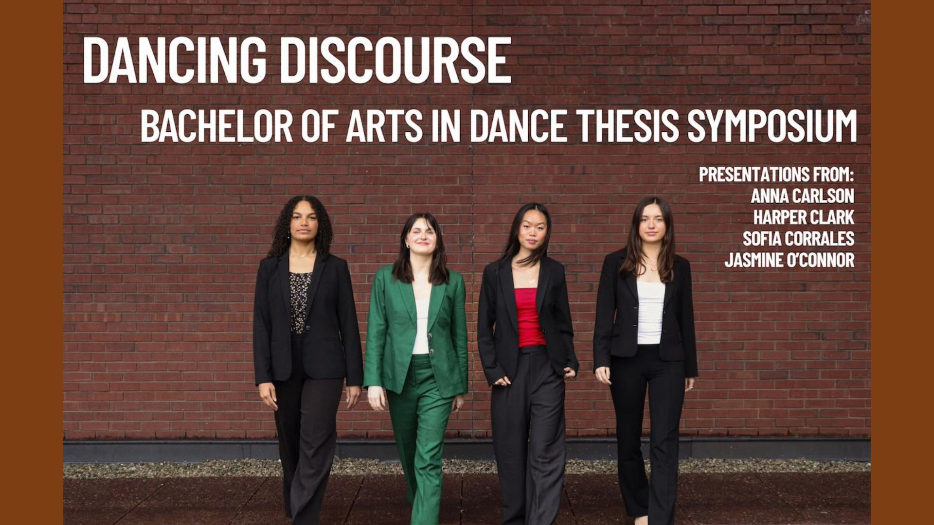 Four students in business attire  in front of a brick wall walking towards the camera