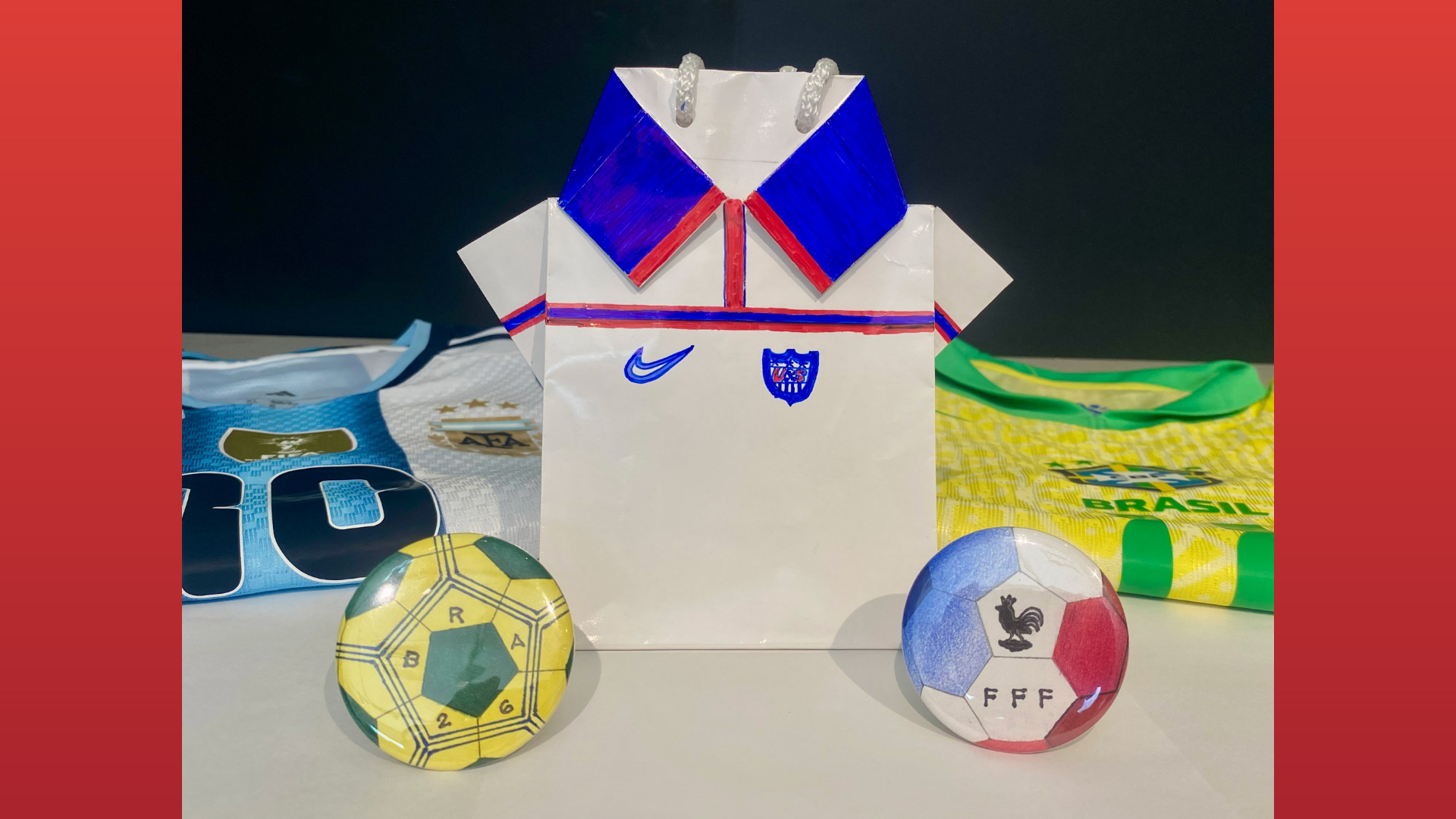 Three international football teams' uniforms with two footballs on a table