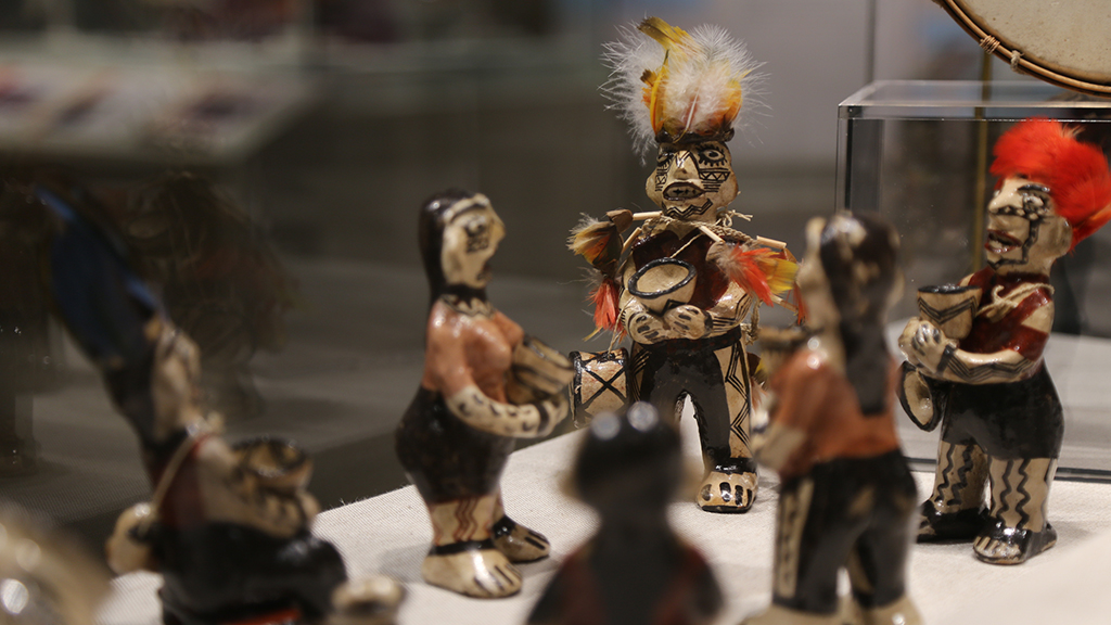 Six small cermaic figures with feather details performing in a circle