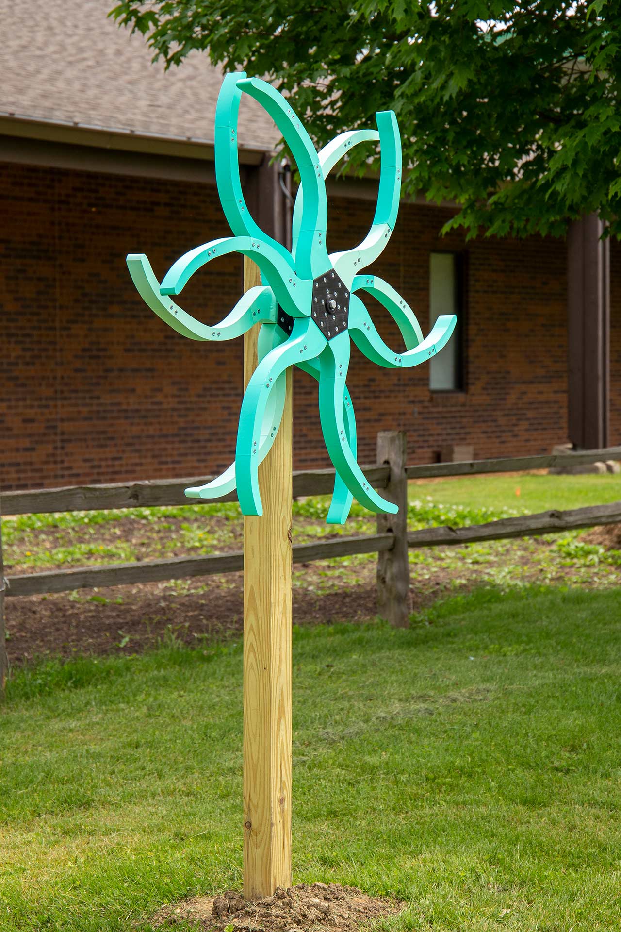 Light-blue tentacles with screws on them that mimic the look of virus nailed on a wooden stick
