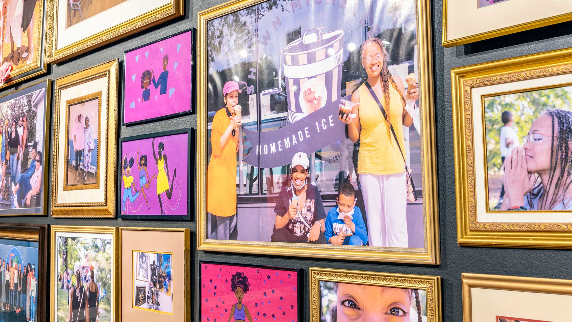 A collage of framed images of smiling black women on a wall