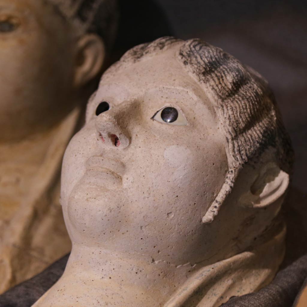 terracotta burial portrait of a woman's upper body including her face, jewelry, and hands