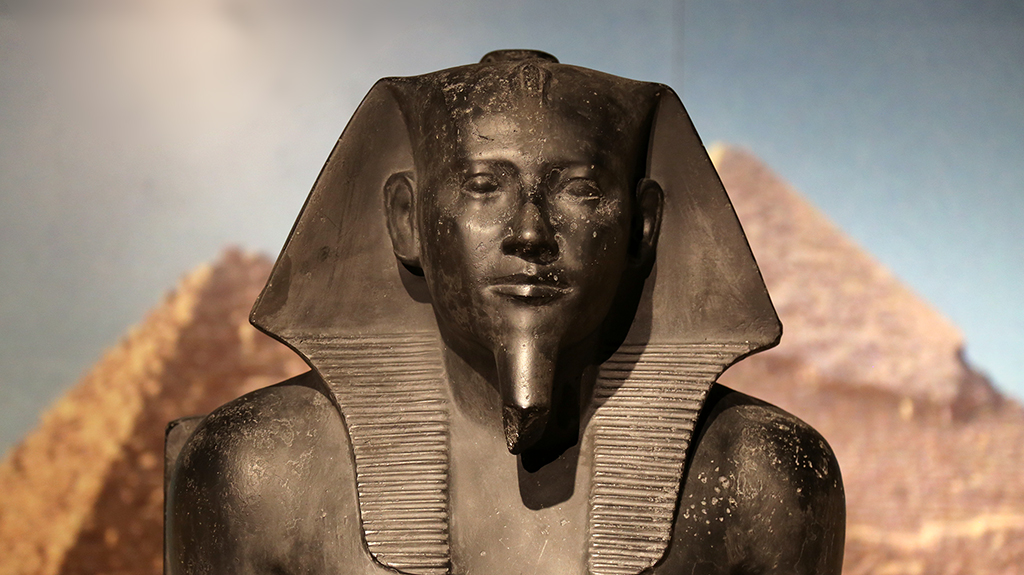 closeup: head of black-colored statue of a pharoah