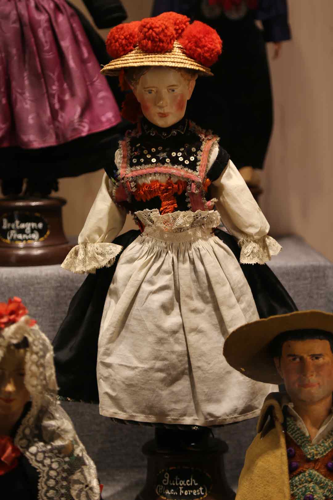 female doll wearing black, whit, and red dress
