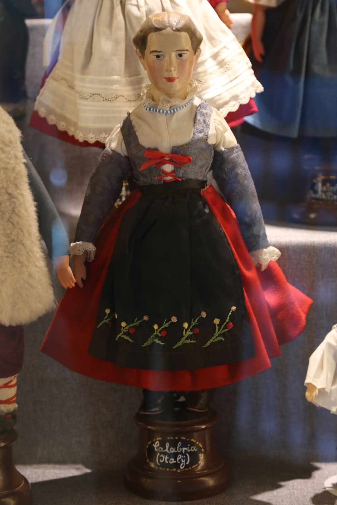 Female doll from Italy wearing a red and black dress with embroidery