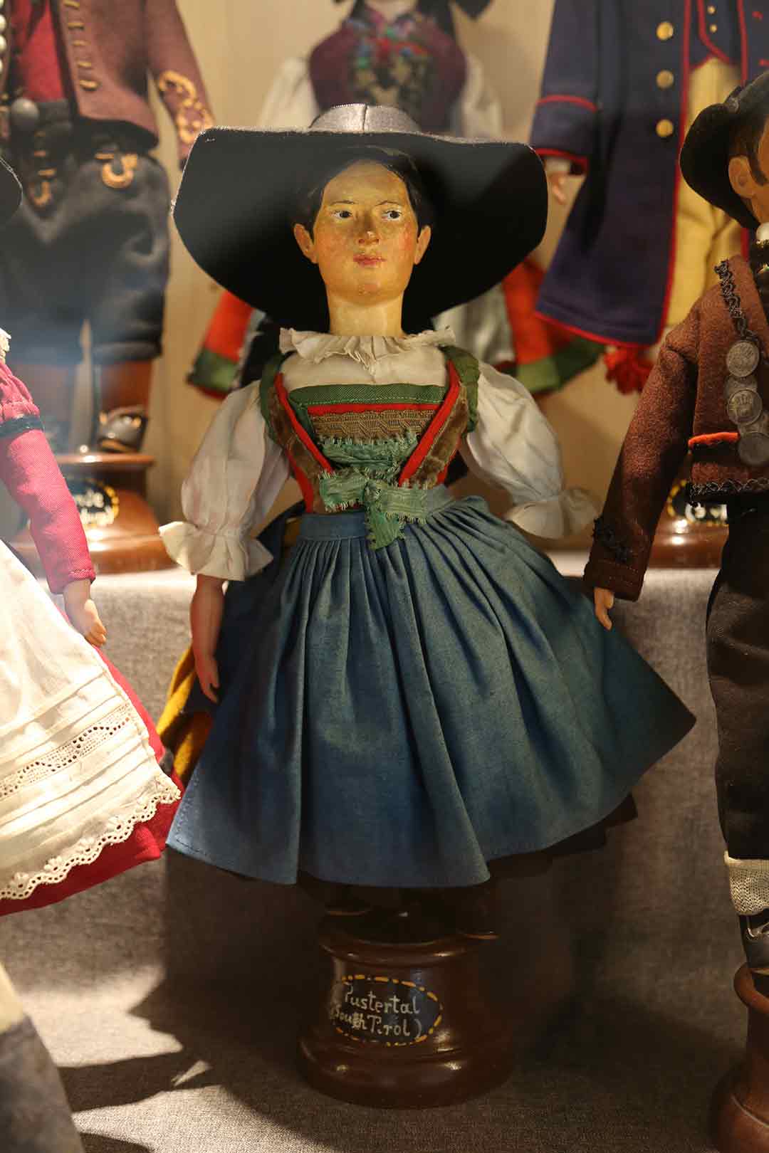 female doll wearing a blue dress and black hat