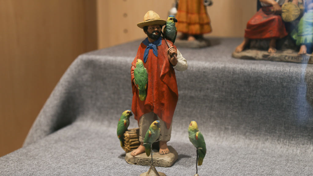 figurine of a man with green parrots