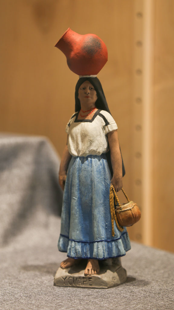 a figurine of a woman with a pot on her head