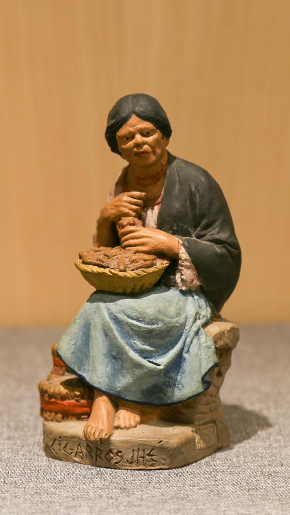 a figurine of a woman sitiing with a basket