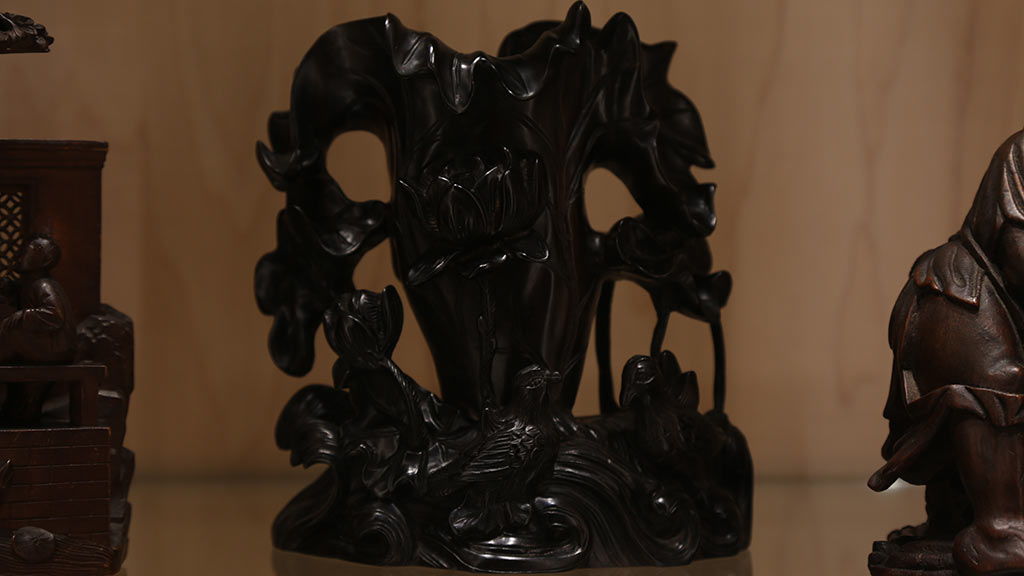 a black sculpture that has birds and flowers