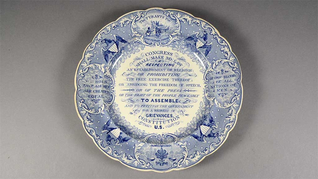 blue and white china plate with a decorative motif listing the first amendment to the US Constitution